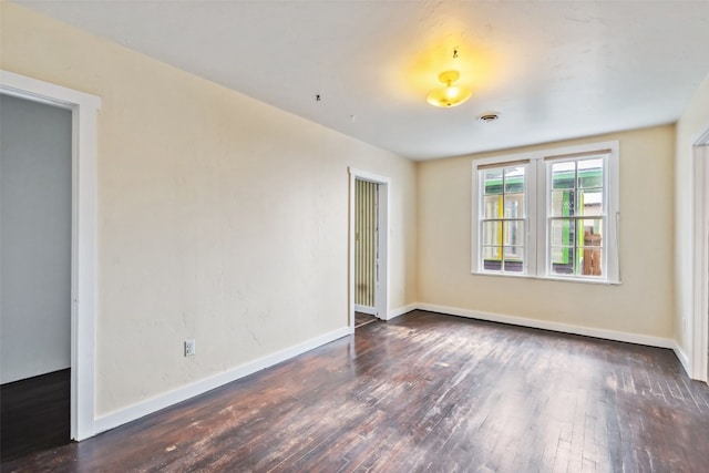 unfurnished room with wood-type flooring, baseboards, and visible vents