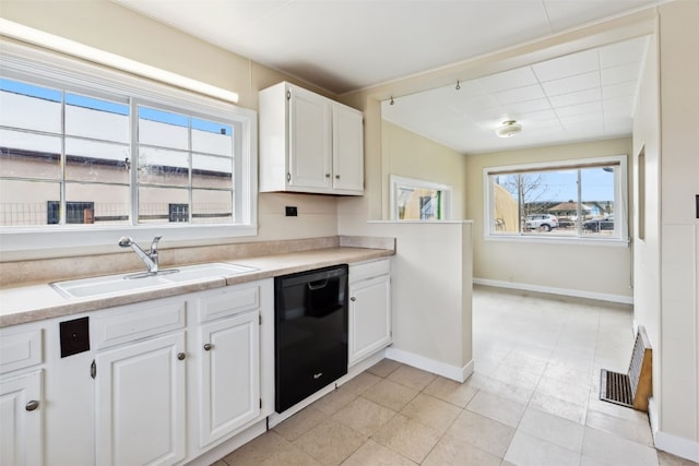 kitchen featuring white cabinets, dishwasher, baseboards, and a sink