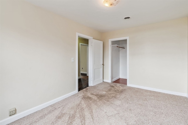 unfurnished bedroom with carpet flooring, a closet, visible vents, and baseboards