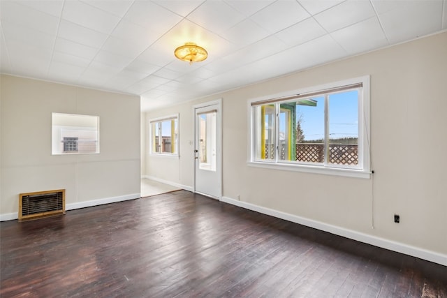 unfurnished living room featuring hardwood / wood-style flooring, baseboards, and visible vents