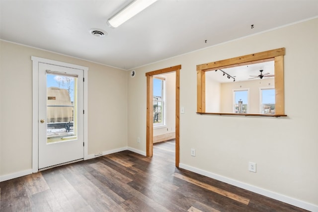 unfurnished room with baseboards, visible vents, plenty of natural light, and wood finished floors