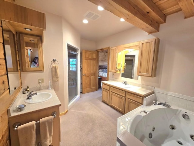 ensuite bathroom featuring a whirlpool tub, a sink, beam ceiling, two vanities, and a stall shower