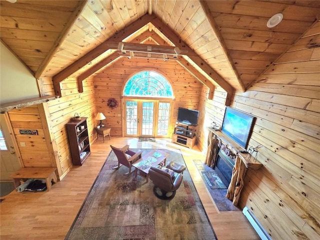 living area with wooden walls, a wealth of natural light, wooden ceiling, and french doors