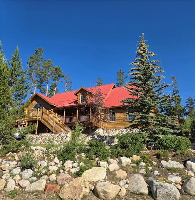 back of house with a deck, stairs, and metal roof
