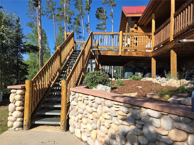 exterior space featuring log exterior, stairway, and a deck