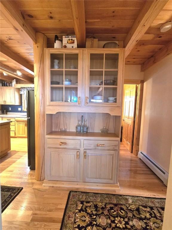 bar with a baseboard heating unit, freestanding refrigerator, and wood ceiling