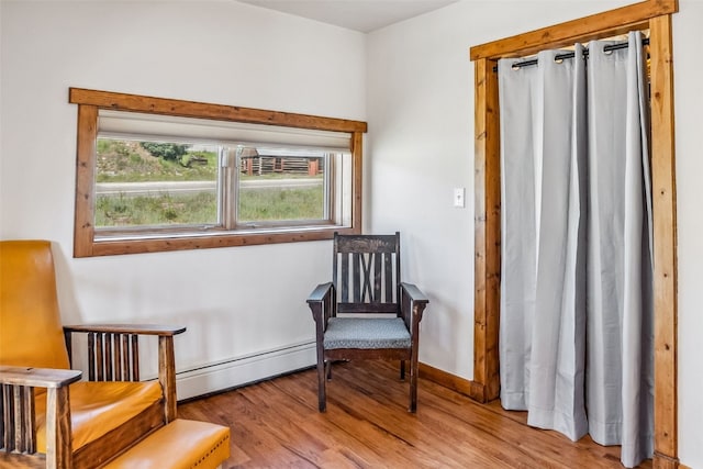 sitting room featuring wood finished floors and baseboard heating