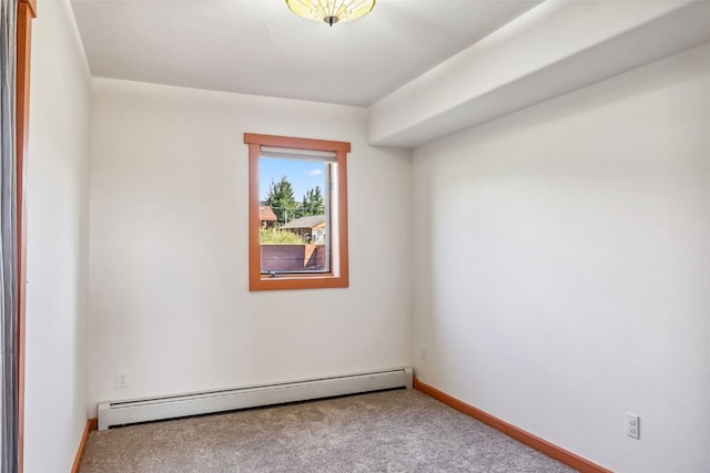 empty room featuring a baseboard heating unit, baseboards, and carpet flooring