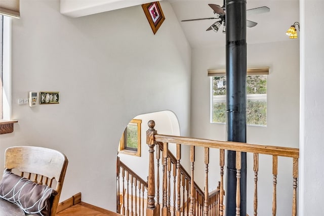 staircase with lofted ceiling and a ceiling fan
