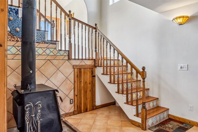 240 S Main St, Alma, CO 80420 - stairway with a wood stove, baseboards, and tile patterned flooring