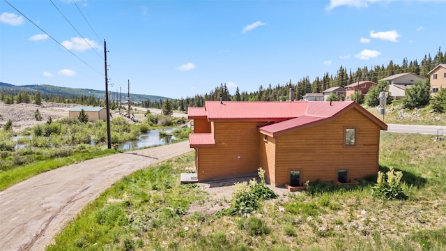 view of property exterior with a mountain view and metal roof