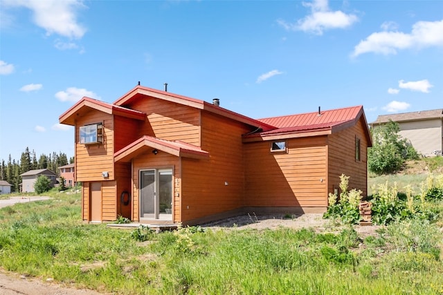 back of house featuring metal roof