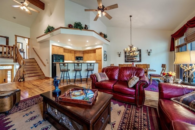 2755 Waterstone Ln Unit 35, Steamboat Springs, CO 80487 - living room featuring a ceiling fan, high vaulted ceiling, stairway, a chandelier, and light wood-type flooring