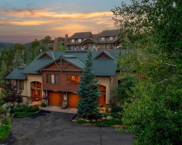 2755 Waterstone Ln Unit 35, Steamboat Springs, CO 80487 - view of front of house featuring an attached garage, stucco siding, asphalt driveway, and a shingled roof