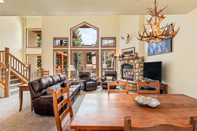 2685 Timber Ct Unit 2, Steamboat Springs, CO 80487 - carpeted living area featuring stairway, a wealth of natural light, a notable chandelier, and a stone fireplace