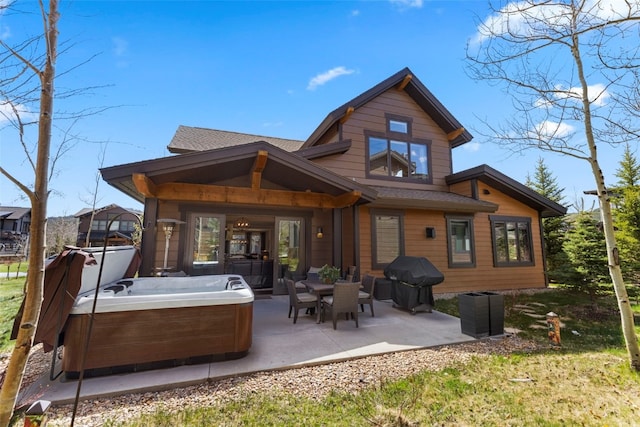 77 Red Quill Ln, Breckenridge, CO 80424 - back of property featuring a hot tub, a patio, and roof with shingles