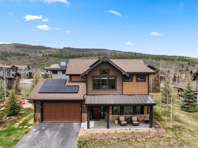 77 Red Quill Ln, Breckenridge, CO 80424 - view of front of property with stone siding, solar panels, asphalt driveway, and a standing seam roof