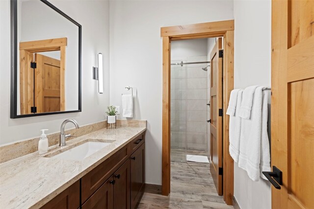 bathroom with vanity, wood-type flooring, and an enclosed shower