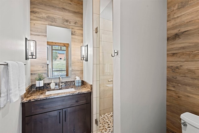 bathroom featuring vanity, toilet, and a shower with door