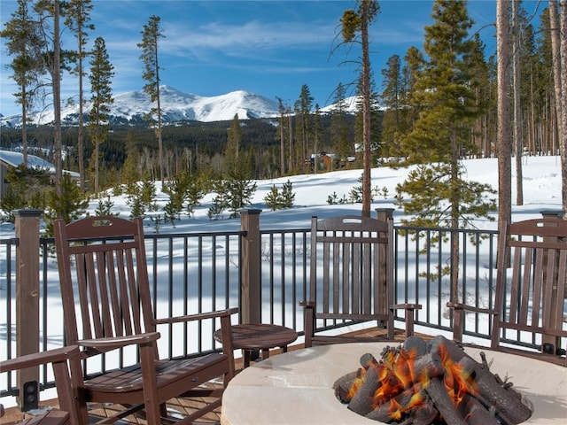 snow covered deck with a mountain view