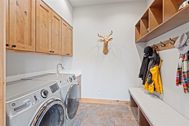 clothes washing area with cabinets, washer and clothes dryer, and sink