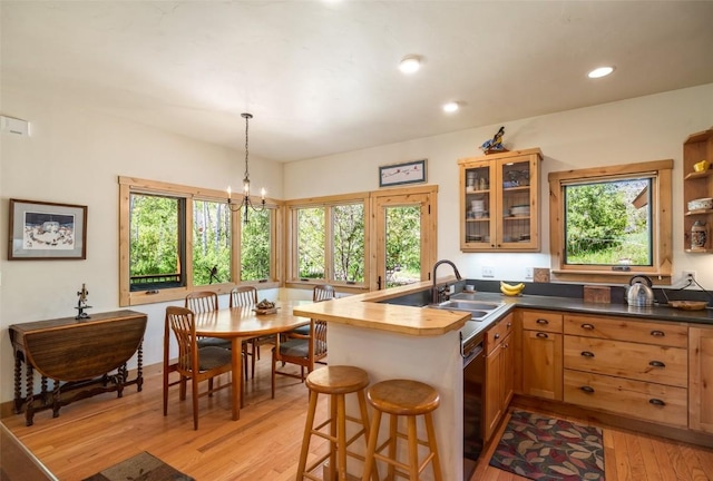 31020 Fallen Falcon Trl, Oak Creek, CO 80467 - kitchen with healthy amount of natural light, light wood-style floors, glass insert cabinets, a peninsula, and recessed lighting