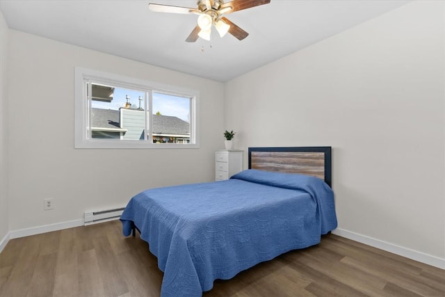 bedroom with baseboard heating, wood finished floors, and baseboards
