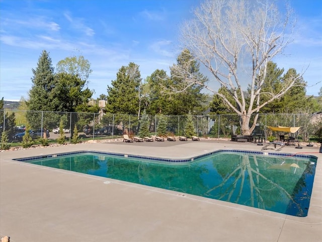 community pool with fence and a patio