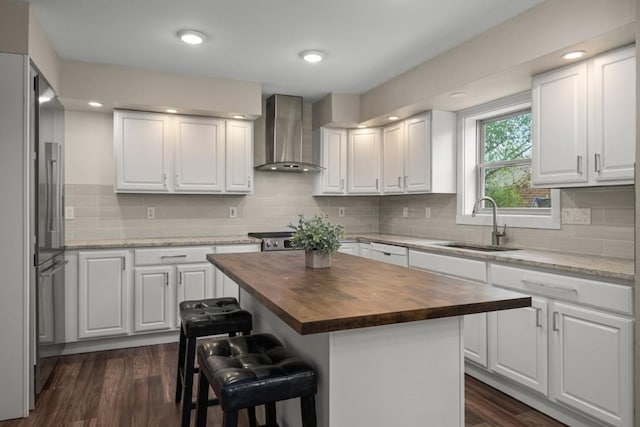 27401 Brandon Cir, Steamboat Springs, CO 80487 - kitchen with wooden counters, wall chimney exhaust hood, a sink, high end refrigerator, and a breakfast bar area