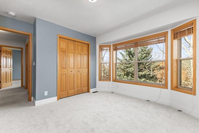 27401 Brandon Cir, Steamboat Springs, CO 80487 - unfurnished bedroom featuring light colored carpet, multiple windows, and a closet