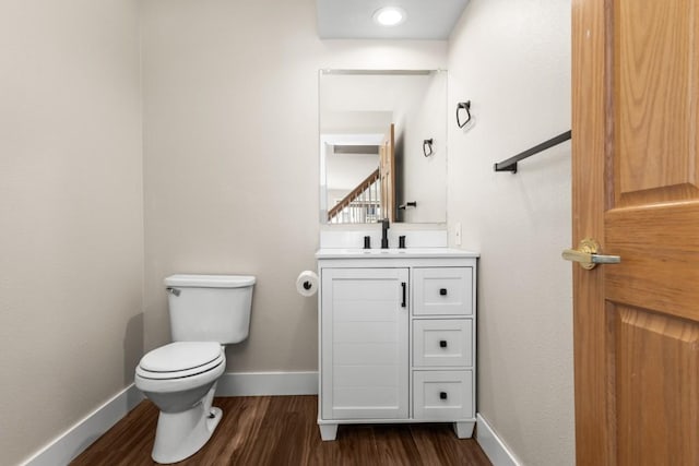 27401 Brandon Cir, Steamboat Springs, CO 80487 - half bath with wood finished floors, vanity, toilet, and baseboards