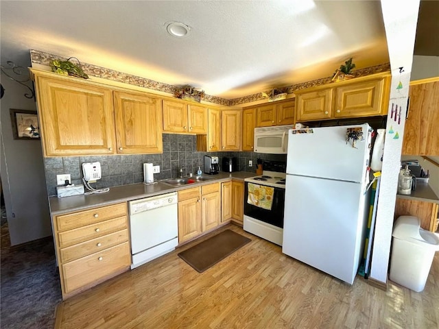kitchen featuring light wood-style floors, tasteful backsplash, a sink, and white appliances