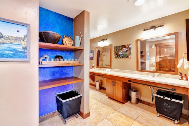 full bathroom featuring tile patterned flooring, baseboards, a sink, and double vanity