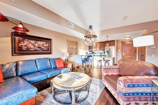 living area with hardwood / wood-style floors and visible vents