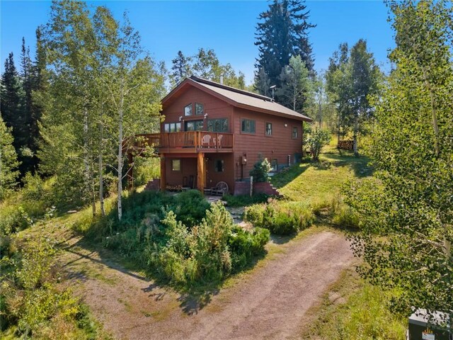 32596 Ute Trl, Oak Creek, CO 80467 - rear view of property with a wooden deck and dirt driveway