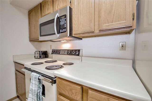 715 S 5th Ave Unit 260, Frisco, CO 80443 - kitchen with white electric range, stainless steel microwave, light brown cabinetry, and light countertops