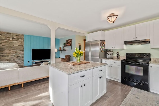 23800 County Road 16 Unit 204, Oak Creek, CO 80467 - kitchen with electric range, freestanding refrigerator, under cabinet range hood, wood finished floors, and white cabinets