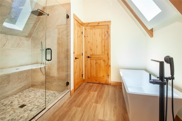 297 Robertson Ln, Breckenridge, CO 80424 - bathroom featuring a skylight, wood finished floors, a soaking tub, a stall shower, and lofted ceiling