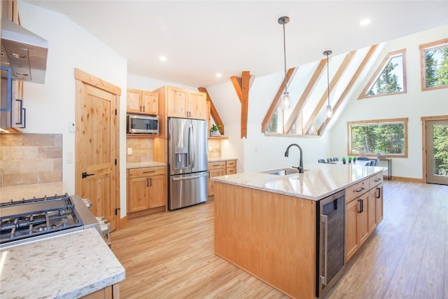 297 Robertson Ln, Breckenridge, CO 80424 - kitchen with appliances with stainless steel finishes, beverage cooler, extractor fan, light brown cabinets, and light wood finished floors