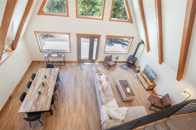 297 Robertson Ln, Breckenridge, CO 80424 - living area featuring a high ceiling, a wood stove, french doors, wood finished floors, and beam ceiling