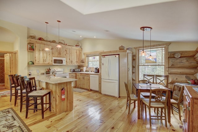 kitchen with a peninsula, light wood-style flooring, arched walkways, vaulted ceiling, and white appliances