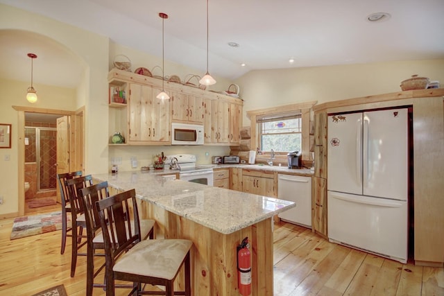 kitchen featuring a peninsula, lofted ceiling, white appliances, and light wood-type flooring