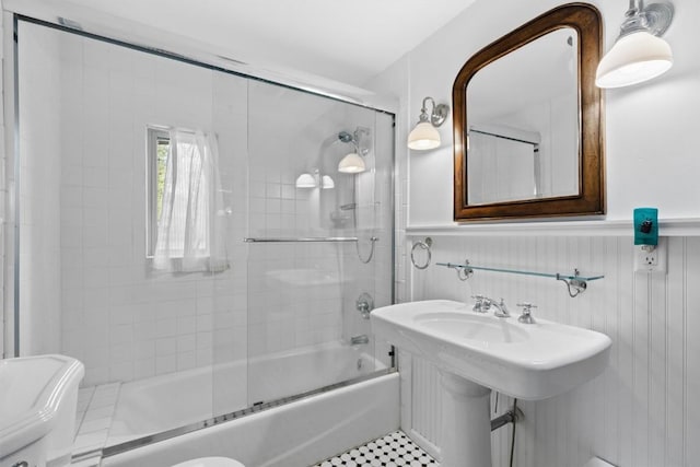820 Yahmonite St, Steamboat Springs, CO 80487 - full bath featuring toilet, combined bath / shower with glass door, a wainscoted wall, and a sink