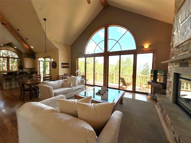 368 Black Hawk Cir, Silverthorne, CO 80498 - living room featuring hardwood / wood-style floors, high vaulted ceiling, beam ceiling, a stone fireplace, and a chandelier