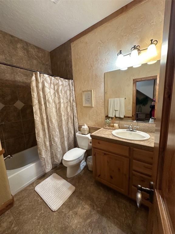 368 Black Hawk Cir, Silverthorne, CO 80498 - full bath with vanity, shower / bath combo, a textured ceiling, and a textured wall