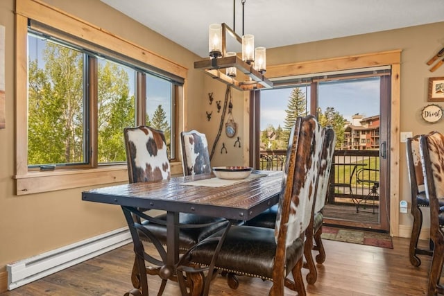1720 Ranch Rd Unit 301, Steamboat Springs, CO 80487 - dining room featuring baseboard heating, a chandelier, wood finished floors, and baseboards