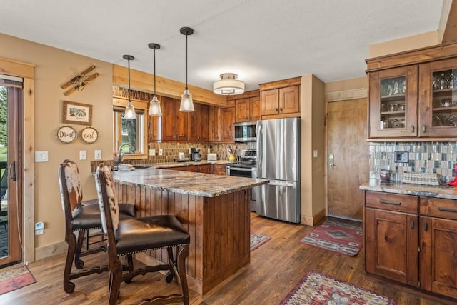 1720 Ranch Rd Unit 301, Steamboat Springs, CO 80487 - kitchen featuring stainless steel appliances, a peninsula, light stone countertops, tasteful backsplash, and a sink