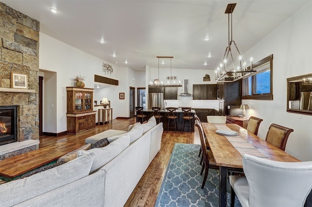 53 Hargrove Way, Silverthorne, CO 80498 - dining area with a chandelier, dark wood-style flooring, a stone fireplace, and recessed lighting
