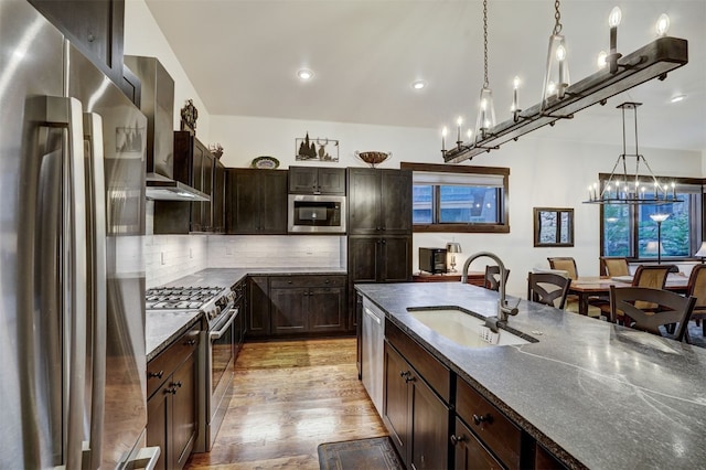 53 Hargrove Way, Silverthorne, CO 80498 - kitchen with stainless steel appliances, a sink, light wood-type flooring, dark brown cabinetry, and a chandelier