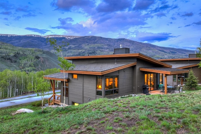 53 Hargrove Way, Silverthorne, CO 80498 - rear view of house featuring a mountain view, a patio area, and a chimney